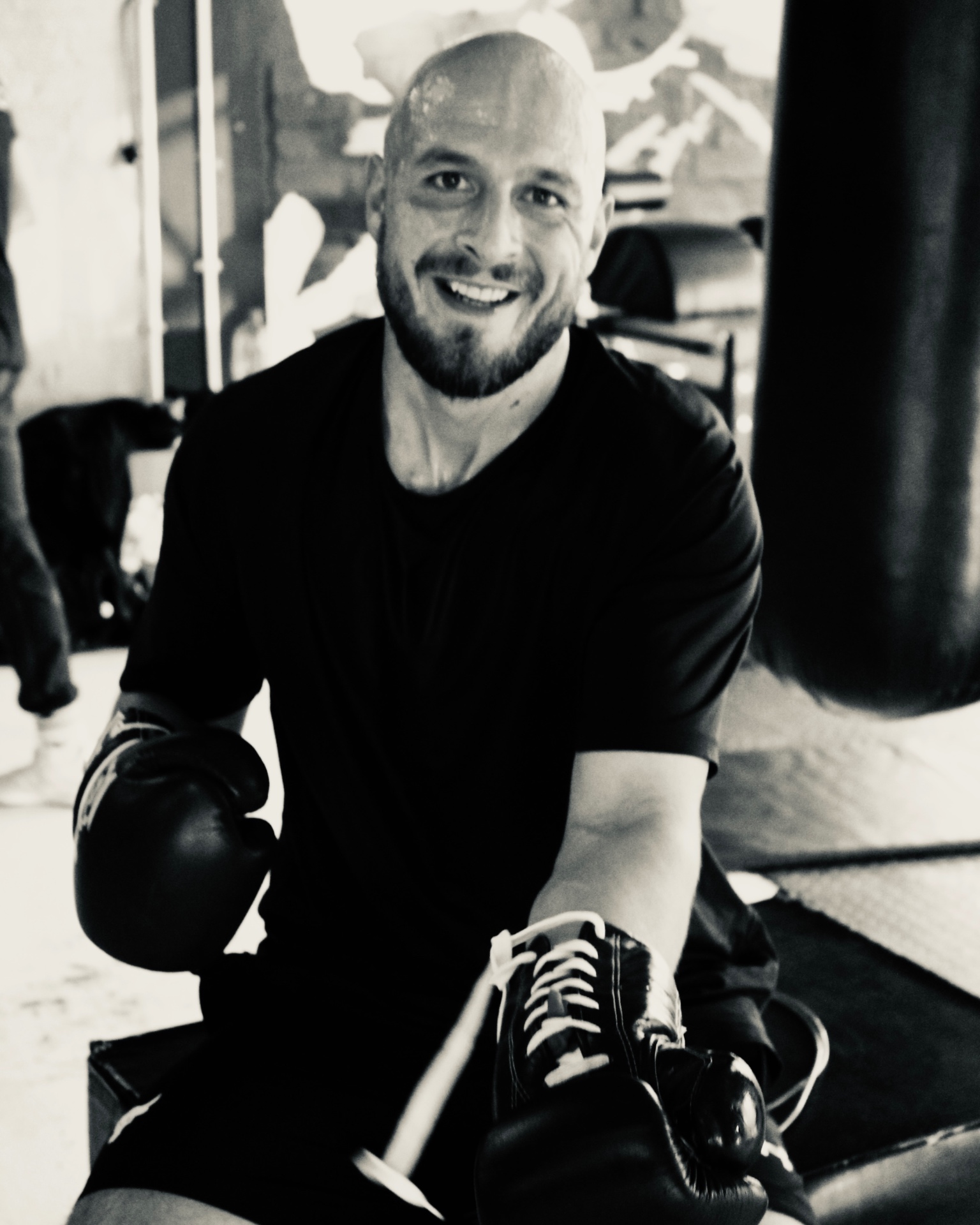 Coach with boxing gloves by the punch bag